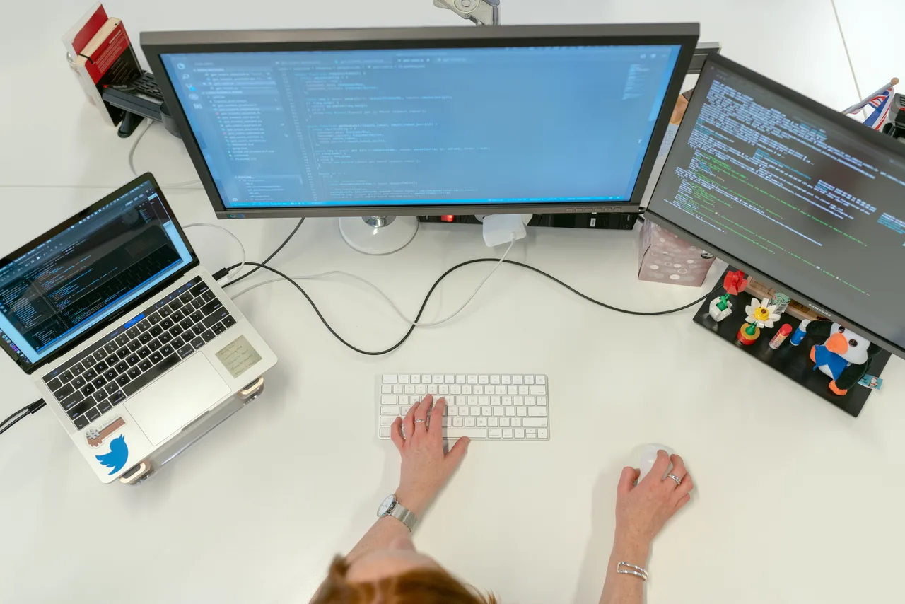 Stanowisko do tworzenia aplikacji z kodem na ekranach komputera i laptopa